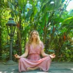 woman in pink dress sitting on wooden pathway